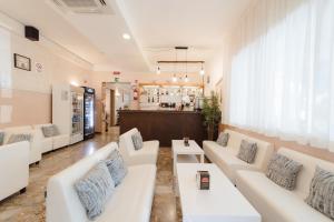 a waiting room with white couches and a pharmacy at Hotel Carol in Cesenatico +22 photos