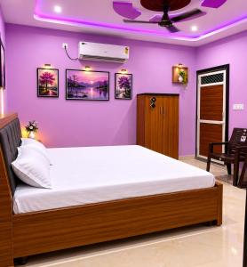 a bedroom with a large bed with purple walls at Bhagwan krishan kutir in Govardhan
