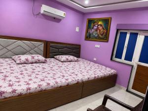 a bedroom with a bed and a purple wall at Bhagwan krishan kutir in Govardhan