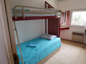 a bedroom with a bunk bed with a blue bedspread at Hôtel Holiday Lyon Est in Saint-Pierre-de-Chandieu