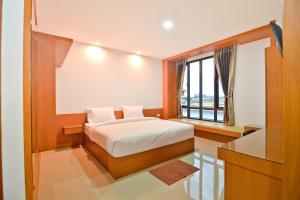 a bedroom with a bed and a large window at Sabuy Best Hotel Phayao in Phayao +26 photos