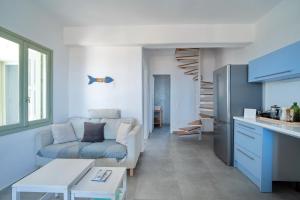 a living room with a couch and a kitchen at Psaraki House Serifos in Serifos Chora +25 photos