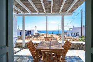 a table and chairs on a patio with a view of the ocean at Psaraki House Serifos in Serifos Chora