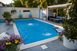 a swimming pool with blue water in a yard at Private Riverside Villa Silvia in Mostar