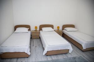 three beds in a room with white walls at Private Riverside Villa Silvia in Mostar +68 photos