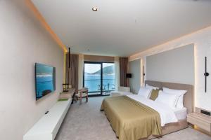 a hotel room with a large bed and a television at Ollie's by the sea in Donja Lastva
