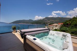 a hot tub on a balcony with a view of the water at Ollie's by the sea in Donja Lastva