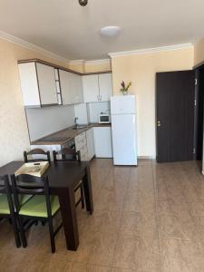 a kitchen with a table and chairs and a refrigerator at Premium Apartments in Sveti Vlas