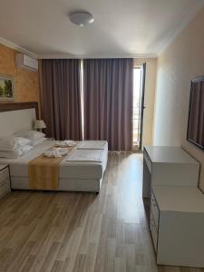 a hotel room with two beds and a television at Premium Apartments in Sveti Vlas +8 photos