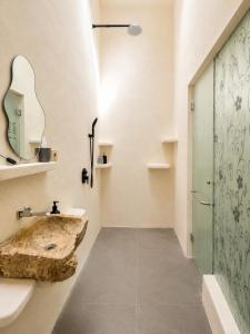a bathroom with a stone sink and a shower at Eve Evy Private Pool Villas in Nusa Lembongan