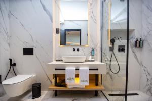 a bathroom with a sink and a toilet and a mirror at Ollie's by the sea in Donja Lastva