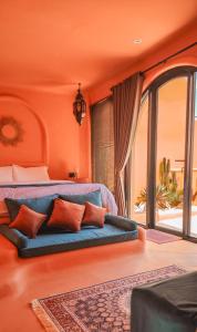 an orange bedroom with a blue couch in front of a window at Güzel Villa Bali in Badung