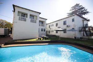 a swimming pool in front of a house at Ecotel Southgate in Southgate