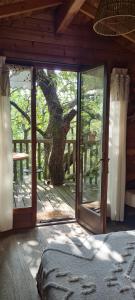 a bedroom with a large glass door with a tree outside at Rêve perché in Apt