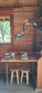 a wooden table with two stools in a cabin at Rêve perché in Apt