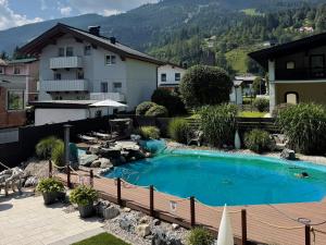 a swimming pool in the backyard of a house at Alpine Appart - Premium Family Apartments and Natural Swimming Pond in Bad Hofgastein