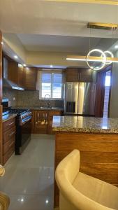 a kitchen with wooden cabinets and a chandelier at Apt cómodo a 6 minuto de megacentro in El Bonito
