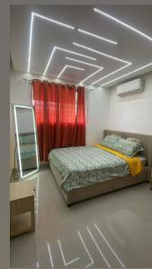 a bedroom with a bed and a mirror and red curtains at Apt cómodo a 6 minuto de megacentro in El Bonito