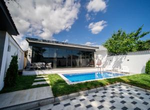 a backyard with a swimming pool and a house at Qafqaz Four Seasons in Gabala