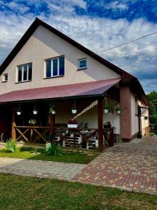 a house with a porch and a fence at У Лариси in Solochyn