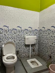 a bathroom with a toilet and a sink at Hotel Lotus in Banbāsa