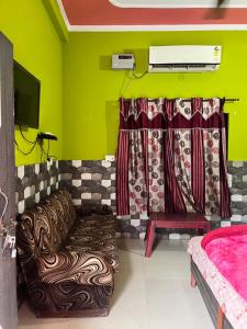 a living room with a couch and a tv at Hotel Lotus in Banbāsa