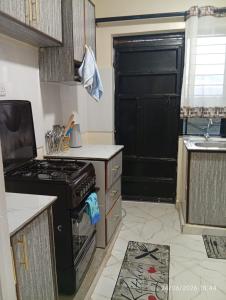 a kitchen with a black stove and a sink at EMIC Suites in Nyahururu
