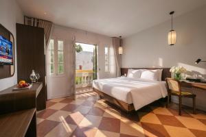 a bedroom with a large white bed and a desk at Pavilion Essence Hanoi Hotel in Hanoi