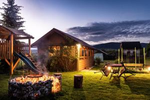 a log cabin with a playground and a slide at Penzion JAS in Zuberec