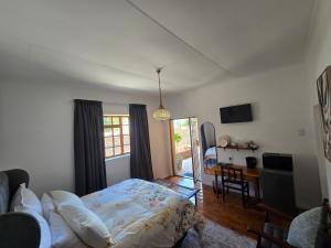 a bedroom with a bed and a table with a desk at Eagles Accommodation in Colesberg