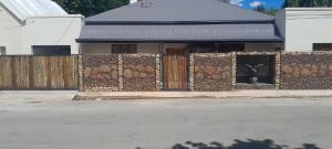 a building with a fence with a gate with at Eagles Accommodation in Colesberg