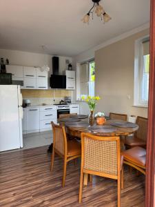 a kitchen and dining room with a table and chairs at Dom nad Jeziorem in Mucharz