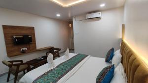 a hotel room with a bed and a tv at hotel shivam comfort in Dhārwād