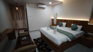a bedroom with a large bed with a wooden headboard at hotel shivam comfort in Dhārwād