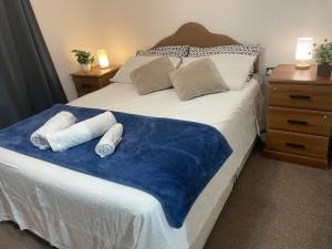 a bedroom with a bed with towels on it at Cozy En-Suite Room with full Home Access in Harrow
