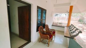 a room with two chairs and a window at Sivadurga in Varkala +2 photos