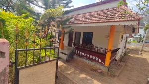 a small house with a balcony and a gate at Sivadurga in Varkala