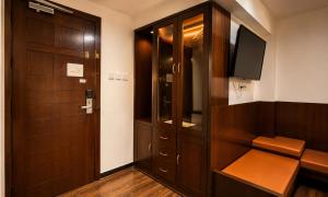a room with a wooden cabinet and a television at Ello Hotels in Bangalore