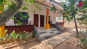 a house on the beach with a person sitting on the porch at Sivadurga in Varkala