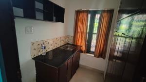 a small kitchen with a sink and a window at Sivadurga in Varkala