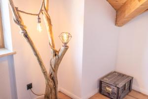a lamp in the corner of a room with a tree at Apartment Bergraum - familienfreundlich und zentral in Sankt Englmar