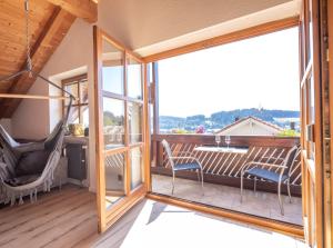 a room with a balcony with a table and chairs at Apartment Bergraum - familienfreundlich und zentral in Sankt Englmar