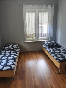 two beds in a room with a window at Hostel Tet6 in Gdynia
