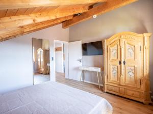 a bedroom with a bed and a wooden cabinet at Apartment Bergraum - familienfreundlich und zentral in Sankt Englmar