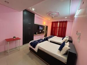 two beds in a room with pink walls at Pine View Guest House in Nāhan