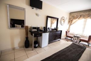 a bedroom with a desk and a mirror at Ecotel Southgate in Southgate
