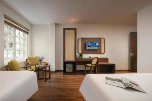 a hotel room with two beds and a tv at Pavilion Essence Hanoi Hotel in Hanoi