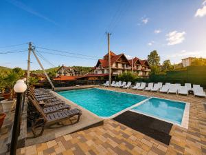 a swimming pool with chaise lounge chairs and a swimming pool at SPA Resort HeRICH in Bukovel