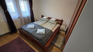 a bedroom with a bed with two towels on it at Apartament Balto in Borsec