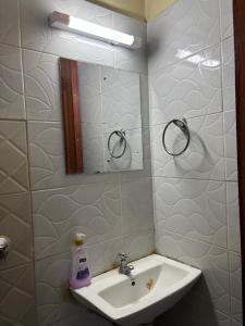 a bathroom with a sink and a mirror at Nesty Homes in Gitura